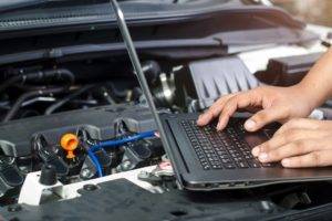 mechanic on a laptop checking car ECU