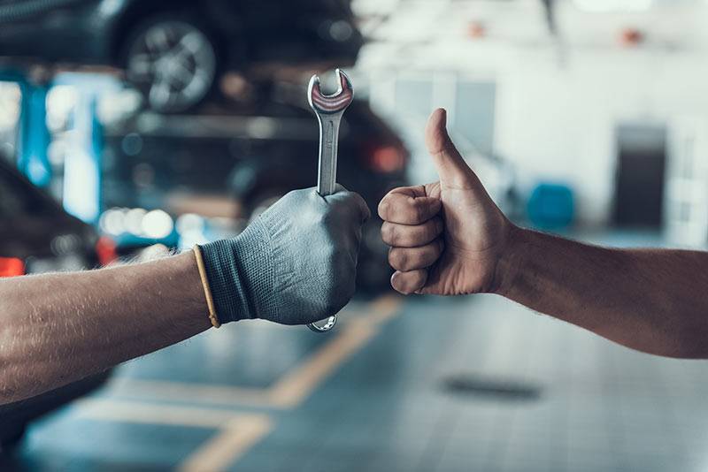 mechanic giving thumbs up with a spanner